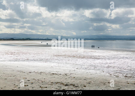 Menschen zu Fuß auf Troon South Beach auf einer stürmischen regnerisch Tag, Schottland, UK Stockfoto