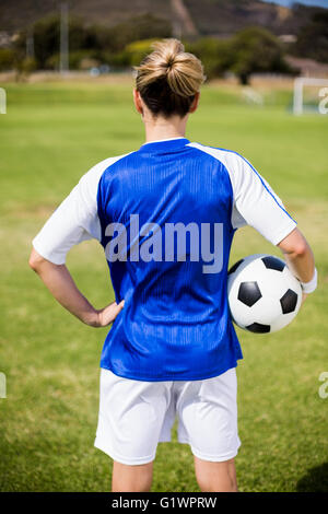 Rückansicht des weiblichen Fußballspieler stehend mit einem ball Stockfoto