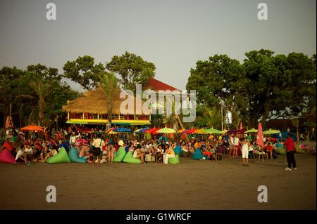 Touristen entspannen und Cocktails und Getränke am Strand von Kuta auf der tropischen Insel Bali in Indonesien. Stockfoto