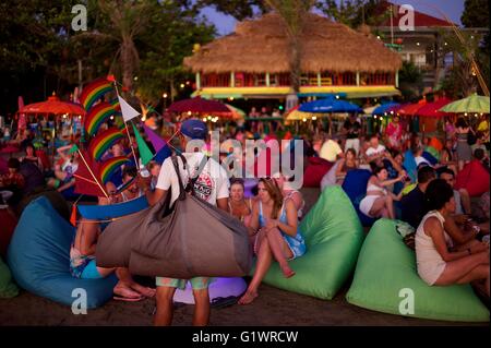 Westliche Urlauber genießen Sie einen Drink am Strand, während die Sonne über der Insel Bali in Indonesien beim trinken Cocktails. Stockfoto