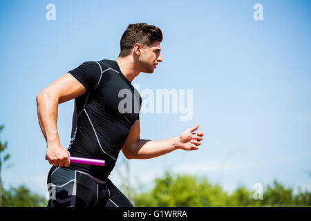 Relais Athlet mit Baton Stockfoto