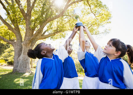 Nahaufnahme der Kinder Fußball Team Arme in die Luft mit Tasse Stockfoto