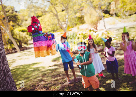 Kleiner Junge geht zur brach ein Pinata zum Geburtstag Stockfoto