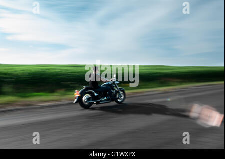Blick auf schöne Biker auf unbekannte Motorrad mit Bewegung zu verwischen, speed Konzept Stockfoto