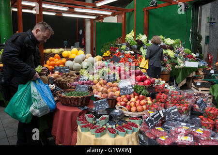 LONDON, UK - 22 MAR: Ein unbekannter Mann kauft Obst und Gemüse in einem Stall in Borough Market in London am 22 März 201 Stockfoto