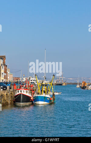 Bunte Fischerboote vertäut am Kai auf dem Fluss Wey in Weymouth Hafen, Dorset, England, UK Stockfoto