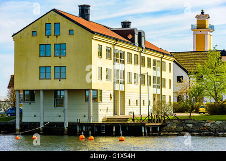 Karlskrona, Schweden - 3. Mai 2016: Coastal Mehrfamilienhaus auf Stumholmen in der Stadt. Gebäude ist gelb, teilweise ruht auf Säule Stockfoto