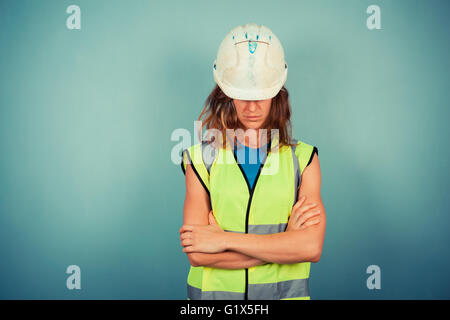 Eine junge Ingenieurin ist eine hohe Vis-Weste und einen Helm tragen. Stockfoto