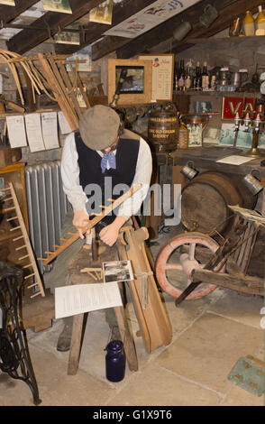 Dent-Dorfmuseum und Heritage Centre, Dent, Yorkshire Dales, England. Ein Lebensmodell Größe eines Mannes machen einen Heu-Rechen. Stockfoto