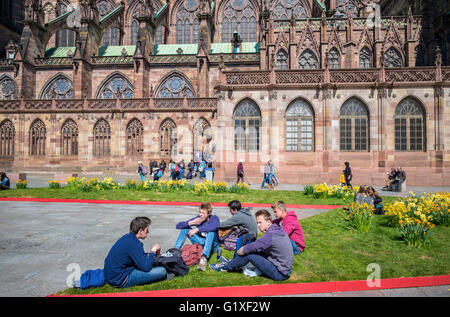 Jugendliche, die entspannend, Place du Château Quadrat und gotische Kathedrale Notre-Dame, 14. Jahrhundert, Straßburg, Elsass, Frankreich Stockfoto