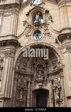 Frontansicht der Basilika/Iglesia de Santa Maria del Coro, San Sebastian, Spanien, zeigt die verzierten religiösen Schnitzereien und Statuen und Uhren Stockfoto