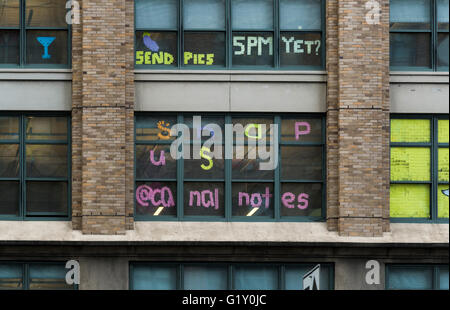 Farbenfrohe Pixelkunst aus Klebezetteln, geschaffen von Mitarbeitern in den Fenstern rivalisierender Bürogebäude an der Canal Street, New York City Stockfoto