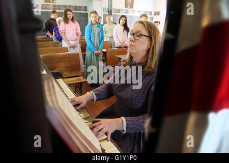 Meilen, Iowa, USA. 19. Mai 2016. Studenten stehen und singen God Bless America als Lehrer, die Heidi Lippens das Klavier in der alten Teeds Hain Nr. 3 Schule auf dem Gelände der Dreschen in Meilen, Iowa Donnerstag, 19. Mai 2016 spielt. Bildnachweis: Quad City Times / ZUMA Draht/Alamy Live News Stockfoto