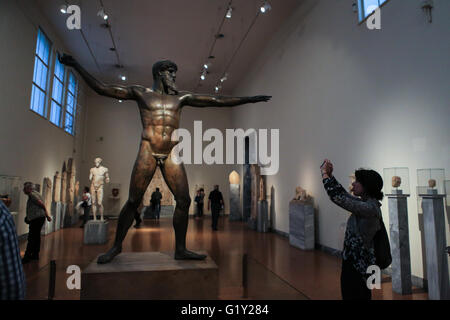 Athen. 18. Mai 2016. Eine Frau nimmt Bilder einer Bronzestatue des Zeus datiert um 460 v. Chr. im Archäologischen Nationalmuseum in Athen am 18. Mai 2016. Unter zahlreichen Artefakten aus der griechischen Antike, in der Haupthalle der Altar des Archäologischen Nationalmuseums in Athen hatten Besucher die Möglichkeit, durch die theatralische Lesung von Homers Odyssee, eines der epischen Gedichte des antiken Griechenlands, anlässlich der Internationalen Museumstag am Mittwoch eine Zeitreise. © Lefteris Partsalis/Xinhua/Alamy Live-Nachrichten Stockfoto