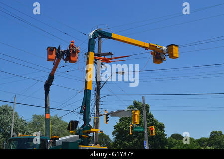 Hydro Arbeiter auf einem Gabelstapler Reparatur hydro Linien in Hamilton, Ontario, unter blauem Himmel. Stockfoto