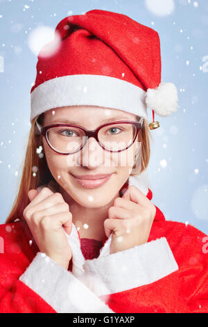 Junge Frau gekleidet wie der Weihnachtsmann im Schnee zu Weihnachten Stockfoto