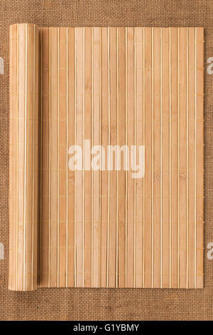 Bambusmatte verdreht in Form eines Manuskripts auf Sackleinen, mit Platz für Ihren text Stockfoto