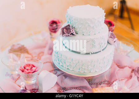 Blaue und weiße Hochzeitstorte dekoriert mit violetten Blüten Stockfoto