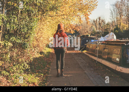 Eine junge Frau trägt Winterkleidung und Hut ist durch den Kanal wandern. Stockfoto