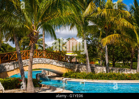 Palmen, steinerne Brücke über Schwimmbad, Iberostar Pararisio Beach Resort, Riviera Maya, Playa del Carmen, Quintana Roo Stockfoto