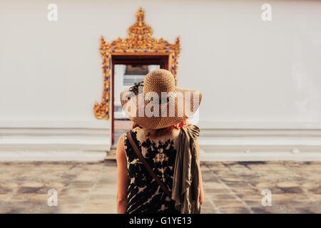 Eine junge Frau blickt auf die aufwendige Eingang zu einem buddhistischen Tempel Stockfoto