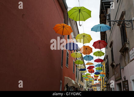 Bunte Schirme oberhalb einer Straße in Novigrad, Kroatien Stockfoto