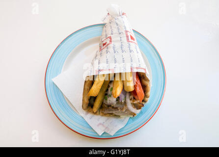 Schweinefleisch Gyros mit Salat und Pommes frites eingewickelt auf einem Teller in Griechenland Stockfoto