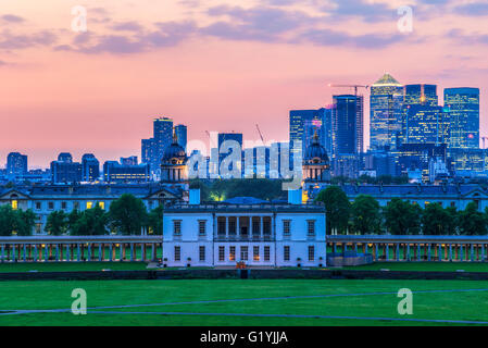 Blick auf Queens House und Canary Wharf vom Greenwich Park, London mit einem Sonnenuntergang Himmel Stockfoto