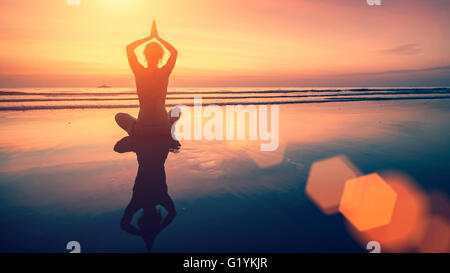 Erstaunliche Yoga Hintergrund, Silhouette der Frau am Strand bei Sonnenuntergang, Meditation und Achtsamkeit. Stockfoto