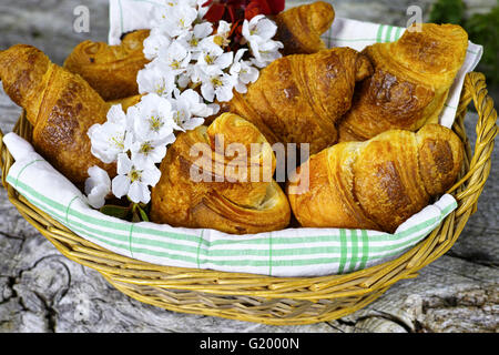 Frische französische Croissants in einem Korb von der Bäckerei auf hölzernen Hintergrund Stockfoto