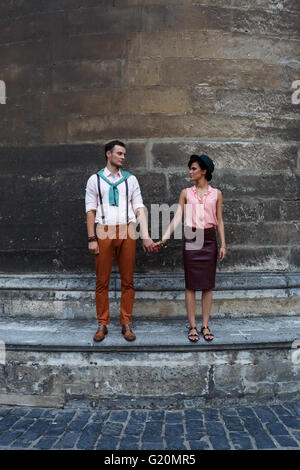 Brünette Braut und Bräutigam zu Fuß in der Nähe der Kirche Stockfoto