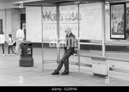 Mann saß auf der Bank in einer Wartehalle in London Stockfoto