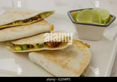 Mexikanische Quesadillas mit Huhn, grüne Bohnen und Lauch auf einem weißen Teller Stockfoto