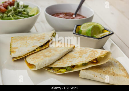 Mexikanische Quesadillas mit Huhn, Grüne Bohnensalat und Salsa auf einem weißen Teller Stockfoto