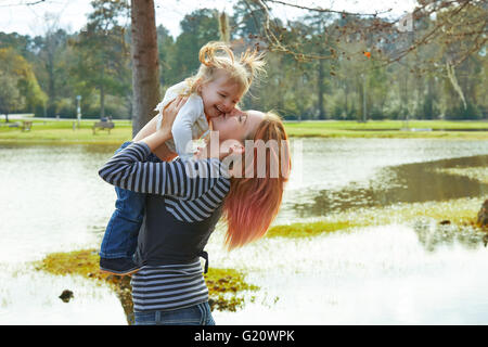 Mutter spielen, werfen sich Baby Mädchen Tochter in dem Park-See Stockfoto