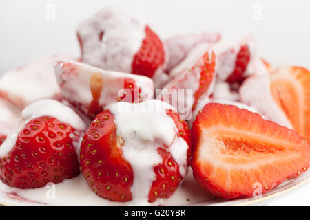 frische Erdbeeren mit Sahne isoliert auf weißem Hintergrund Stockfoto