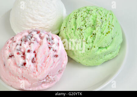 drei Kugeln Eis auf weißen Teller, grün und weiß ganz nah, full Frame, horizontale Stockfoto