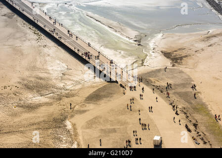 Anzeigen von Wänden des Mont Saint Michel an der Bucht während der Ebbe. Gruppen von Touristen zu Fuß. Frankreich Stockfoto