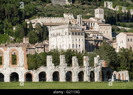 Gubbio, Umbrien. Im Vordergrund, das antike römische Theater. Im Hintergrund die Skyline von der mittelalterlichen Stadt. Stockfoto