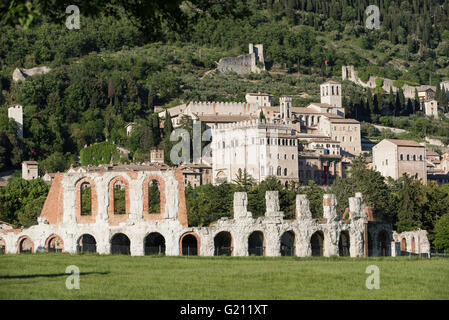 Gubbio, Umbrien. Im Vordergrund, das antike römische Theater. Im Hintergrund die Skyline von der mittelalterlichen Stadt. Stockfoto