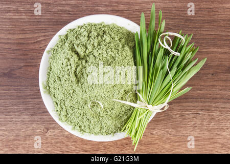 Gerstengras mit Haufen von jungen Pulver Gerste in Glasschüssel auf hölzernen Hintergrund, gesunde Ernährung und Lifestyle, Body detox Stockfoto