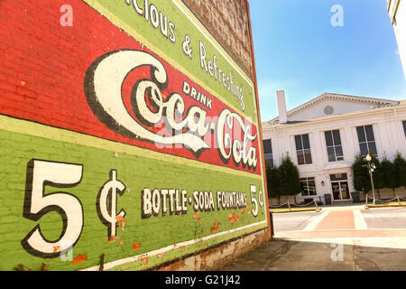 Altes Coca Cola Schild gemalt auf ein Gebäude und historische County Courthouse in der Innenstadt von Laurens, South Carolina. Stockfoto