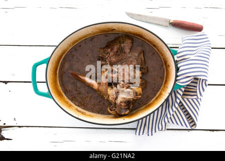 Langsam gekochtes Lamm mit Zwiebeln und Rotwein auf alten Holztisch Stockfoto