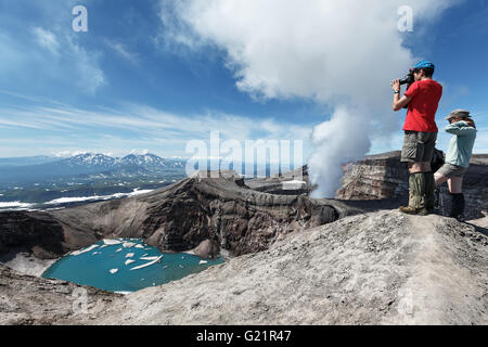 Touristen im Krater des aktiven Gorely in Kamtschatka nimmt ein Bild vulkanische Krater, Kratersee und aktive Fumarolen. Stockfoto