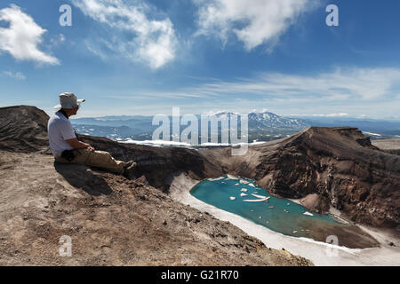 Tourist in den Krater des aktiven Gorely Vulkanbeobachtung am schönen Kratersee. Russland, Kamtschatka. Russland, Fernost, Kamtschatka Stockfoto