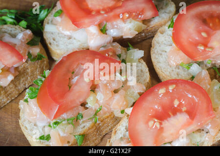 Sandwiches mit Lachs und Tomaten auf Holztisch Stockfoto