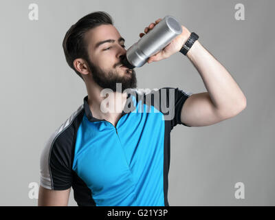 Durstig junge bärtige Radfahrer Trinkwasser aus Kunststoff-Flasche Stockfoto