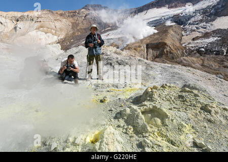 Fotografen im Mutnovsky Vulkan-Krater in der Nähe von aktiven Schwefel Fumarolen, auswerfen, Dampf und Gas. Kamtschatka-Halbinsel. Stockfoto