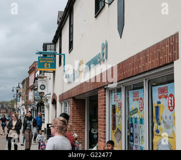 Ein beliebter Discounter in der Einkaufsstraße, der in einer beliebten Marktstadt zu sehen ist, und an einem geschäftigen Wochenende die Käufer vorbeilaufen sehen. Stockfoto