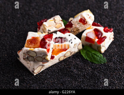 Weiche Nougat mit tropischen Früchten auf schwarzem Sesam Stockfoto